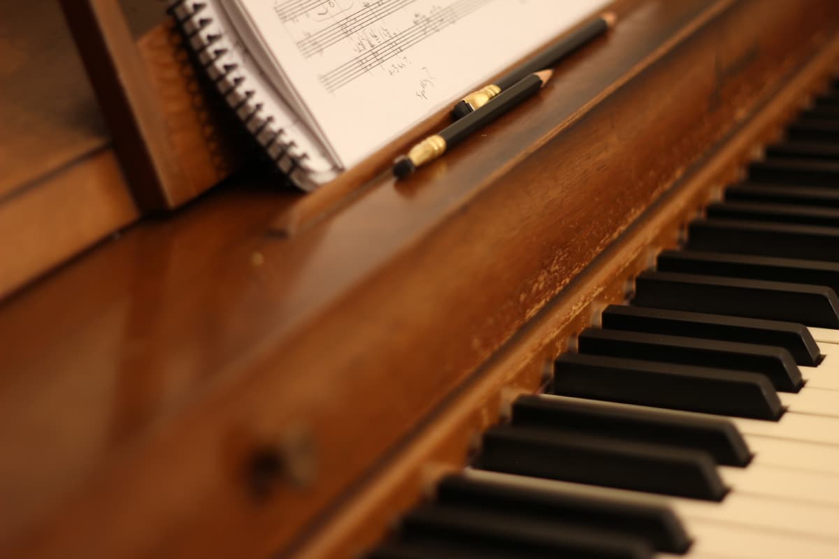 closeup of piano with musical score and pencil
